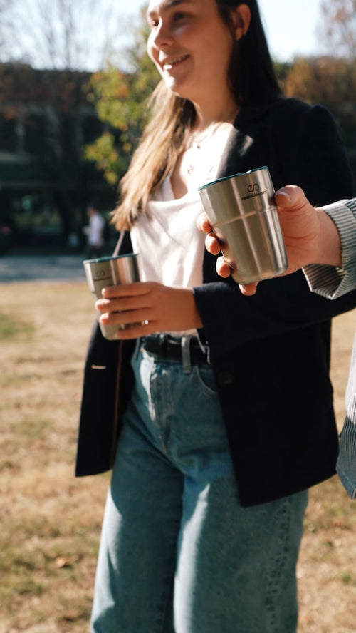 Reusables' CEOs showcasing eco-friendly cups at a park